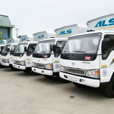 Đoàn xe tải thùng đỗ thẳng hàng trước kho