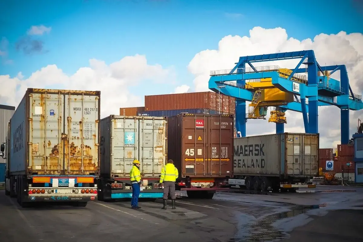Xe đầu kéo chở container tại bãi cảng có cẩu giàn
